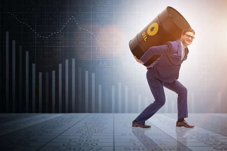 Businessman under the burden of oil barrelの写真素材