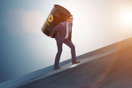 Businessman under the burden of oil barrelの写真素材