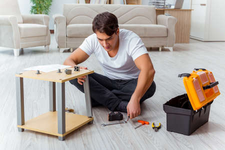 Man assembling furniture at homeの写真素材