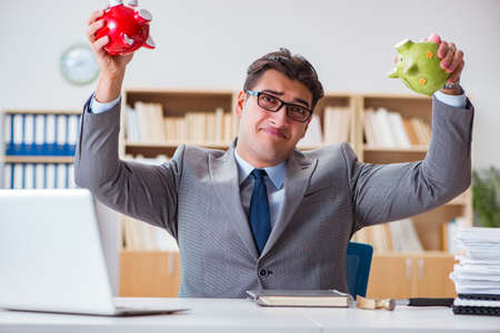 Businessman breaking piggybank in the officeの写真素材