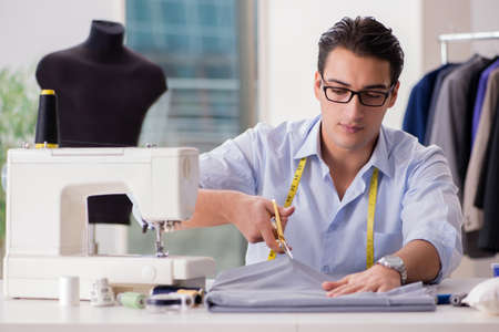 Young man tailor working on new clothingの写真素材