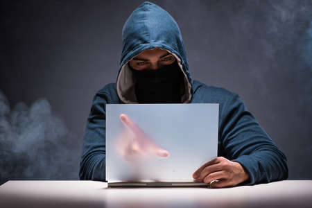 Computer hacker working in dark room