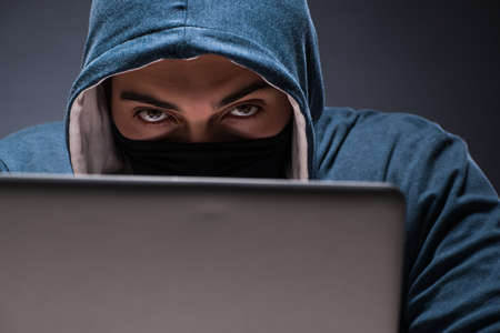 Computer hacker working in dark roomの写真素材