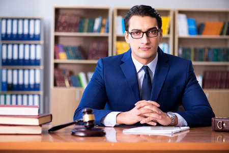 Handsome judge with gavel sitting in courtroomの写真素材