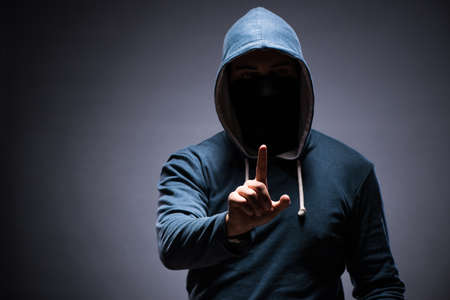 Man wearing hood in dark room