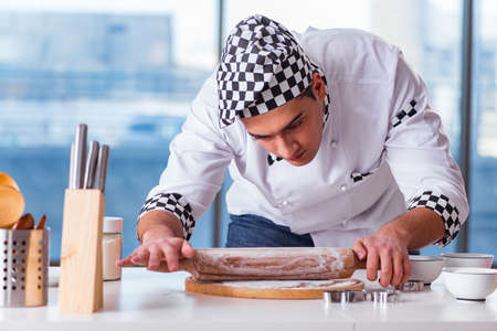 Young man cooking cookies in kitchen
