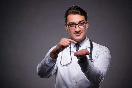 Young doctor against dark backgroundの写真素材