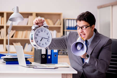 Businessman with loudspeaker megaphone in officeの写真素材
