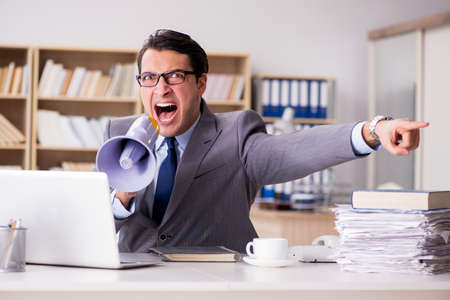 Angry businessman working in the officeの写真素材