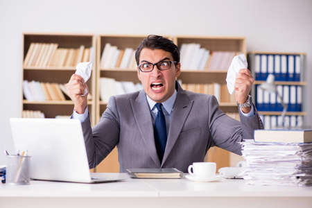 Angry businessman working in the officeの写真素材
