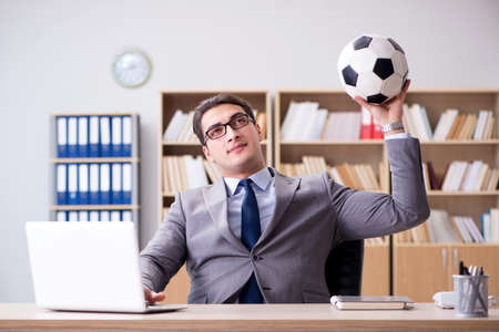 Businessman with football ball in officeの写真素材
