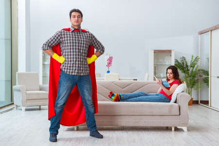 Superhero husband helping his wife at homeの写真素材