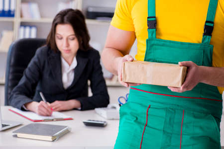 Postman delivering parcel to the officeの写真素材
