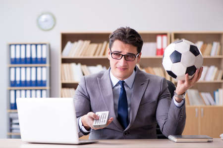 Businessman with football ball in officeの写真素材