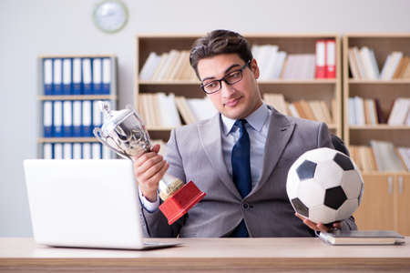 Businessman with football ball in officeの写真素材