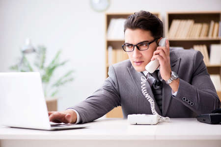 Helpdesk operator talking on phone in officeの写真素材