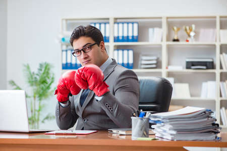Angry aggressive businessman with boxing glovesの写真素材