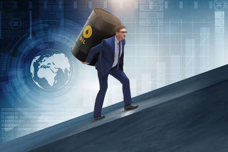 Businessman under the burden of oil barrelの写真素材