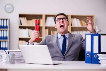 Businessman with dynamite in the officeの写真素材