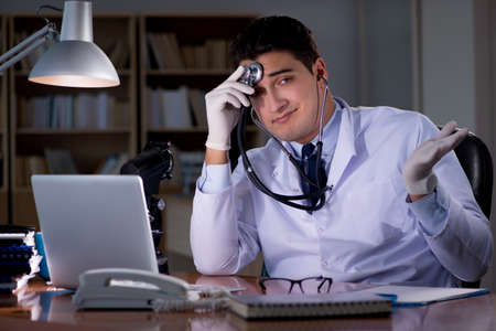 Young doctor working late in the officeの写真素材
