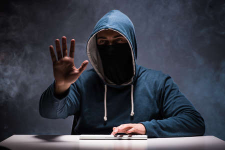 Computer hacker working in dark roomの写真素材