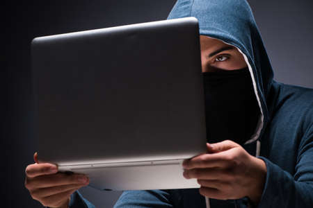 Computer hacker working in dark roomの写真素材