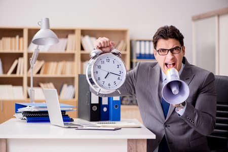 Businessman with loudspeaker megaphone in officeの写真素材