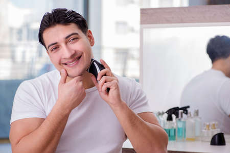 Young handsome man shaving in the morningの写真素材