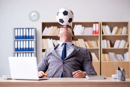 Businessman with football ball in officeの写真素材