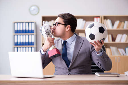 Businessman with football ball in officeの写真素材