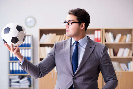 Businessman with football ball in officeの写真素材