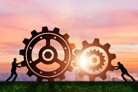 Businessman in teamwork concept with cogwheelsの写真素材