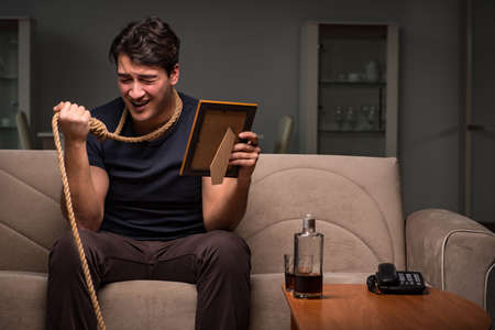 Bankrupt businessman holding a photo frame and a nooseの写真素材