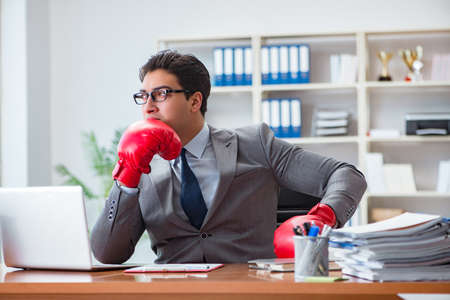 Angry aggressive businessman with boxing glovesの写真素材