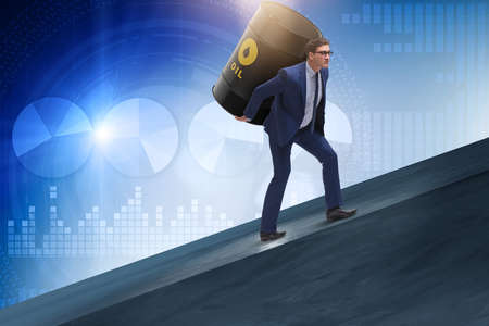 Businessman under the burden of oil barrelの写真素材