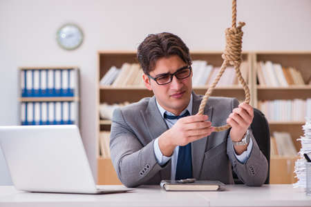 Concept of bankrupt businessman holding onto nooseの写真素材