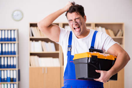 Funny worker with dirty face and toolkitの写真素材