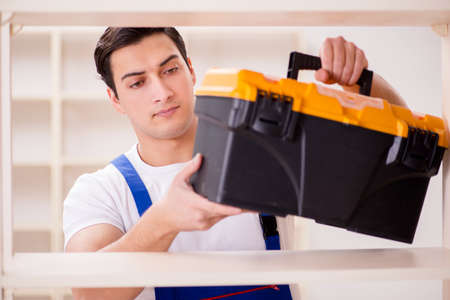 Worker man repairing assembling bookshelf