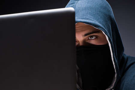 Computer hacker working in dark room