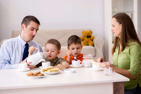 Happy family having breakfast together at homeの写真素材