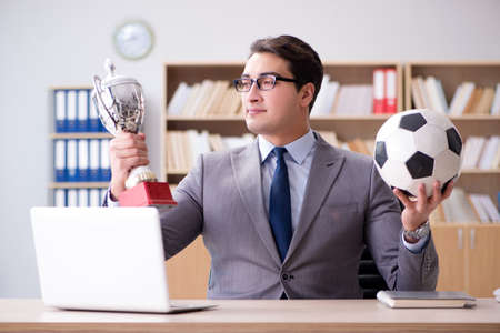 Businessman with football ball in officeの写真素材