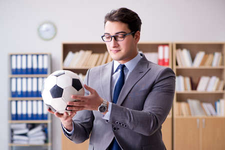 Businessman with football ball in officeの写真素材