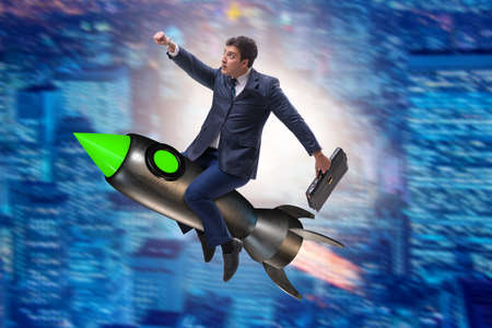 Male businessman flying on rocket in business conceptの写真素材