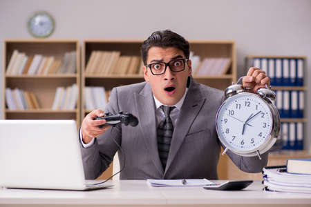 Businessman playing computer games at work officeの写真素材