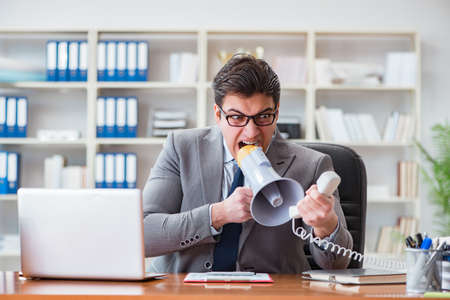 Angry aggressive businessman in the officeの写真素材