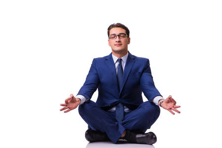 Businessman meditating on the floor isolated on whiteの写真素材