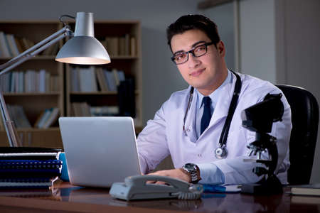 Young doctor working late in the officeの写真素材