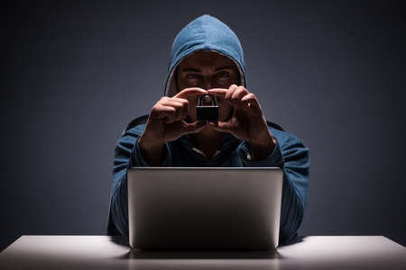 Computer hacker working in dark room
