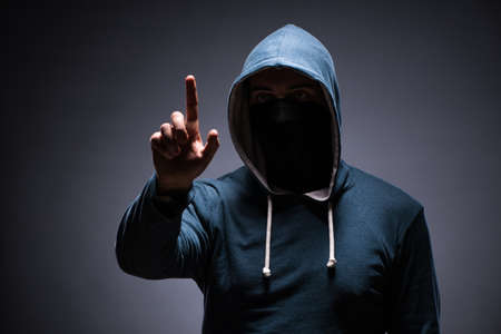 Man wearing hood in dark roomの写真素材