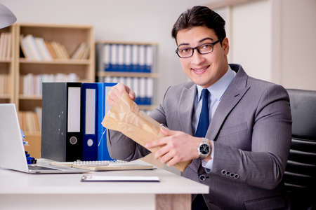 Businessman receiving parcel in officeの写真素材